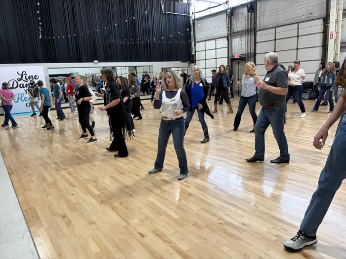 A large open hall with dancers spread across the floor