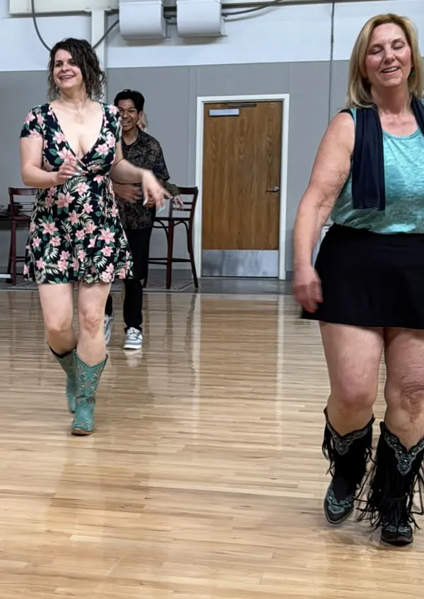 Two dancers laughing as they finish a dance