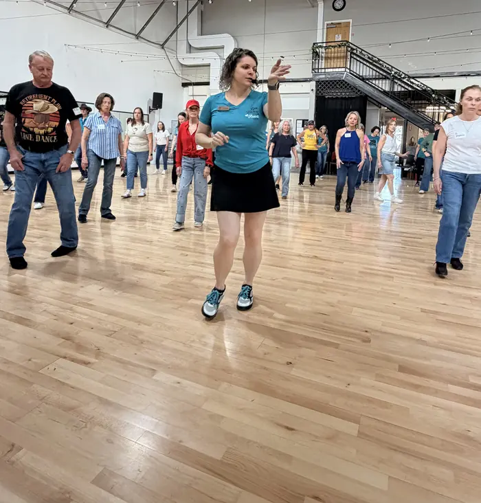 An instructor demonstrating a step to a full room of dancers